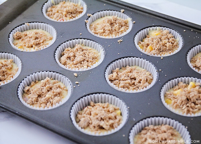 uncooked batter in a muffin tin topped with cinnamon and sugar