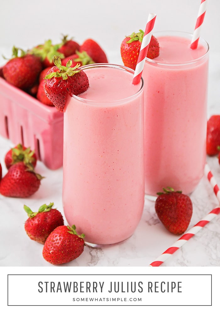 a close up of a strawberry Julius frozen drink next to a small crate of fresh strawberies