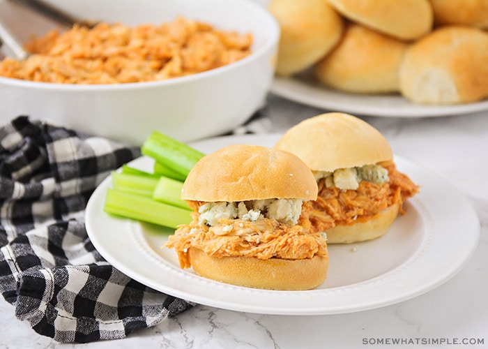 two buffalo chicken sliders on a plate with celery sticks