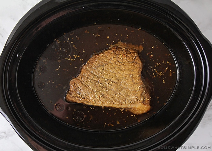 a cooked pot roast in a slow cooker