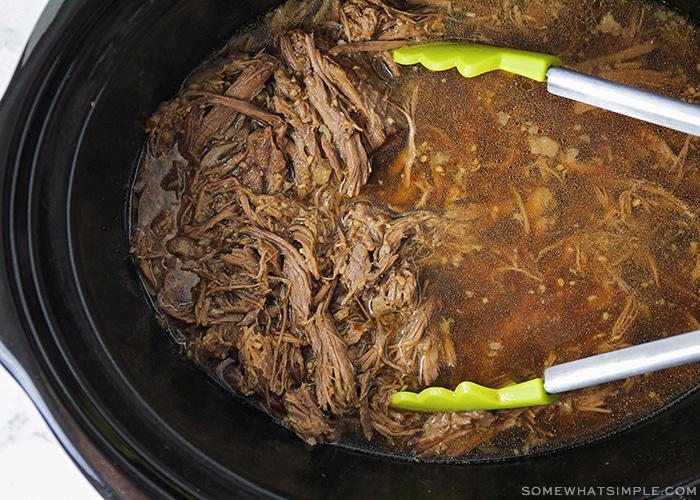 shredded beef in a crock pot in broth