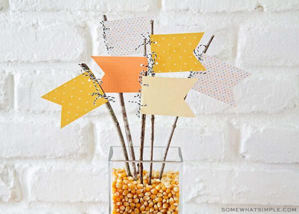 fall centerpiece with popcorn kernels and paper pennants