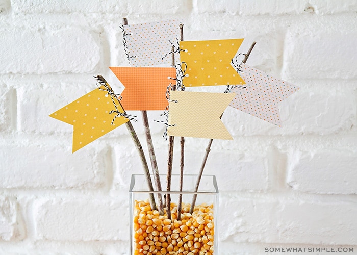 fall centerpiece with popcorn kernels and paper pennants