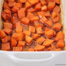 a baking pan filled with candied yams in a brown sugar glaze