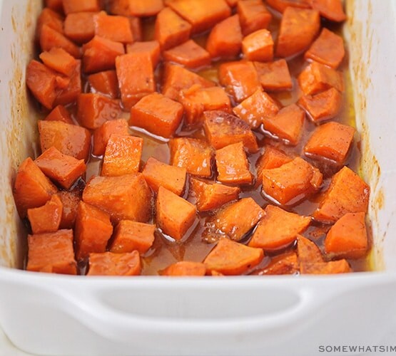 a baking pan filled with candied yams in a brown sugar glaze