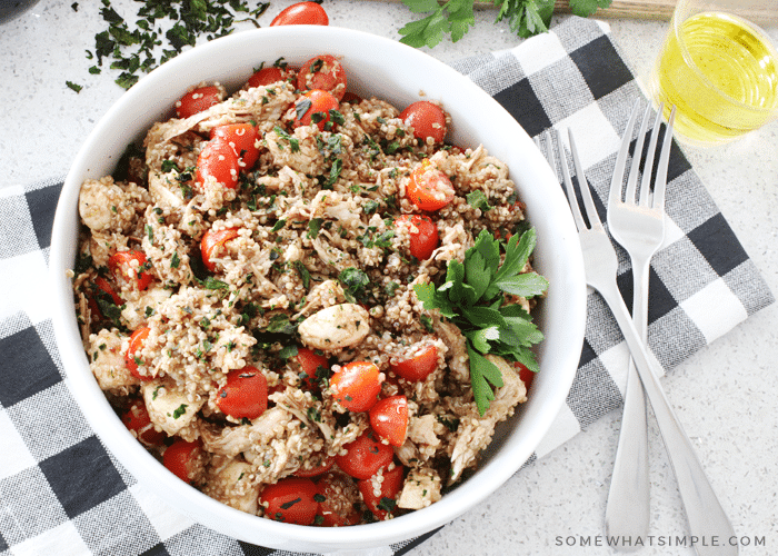 a bowl filled with Caprese quinoa chicken salad that's been tossed