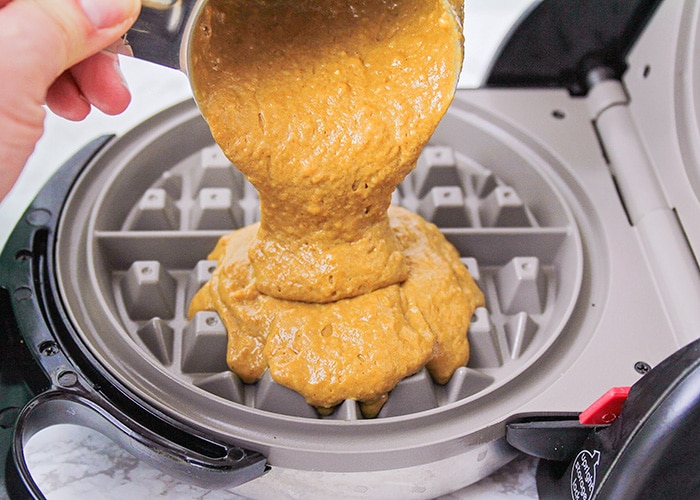 waffle batter being poured into a waffle maker