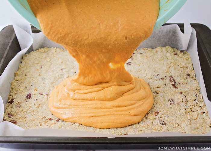 a pumpkin mixture being poured over a baked crust