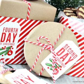 Free 12 Days of Christmas Gift Tags shown on red and white packages under the tree