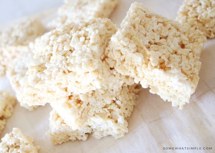 stack of Rice Krispie treats on a cutting board and wax paper