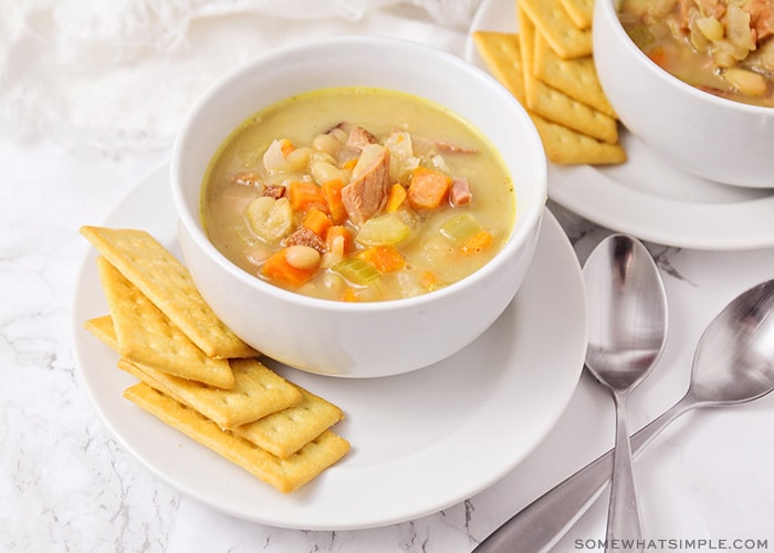 A bowl of soup filled with ham, white beans and vegetables