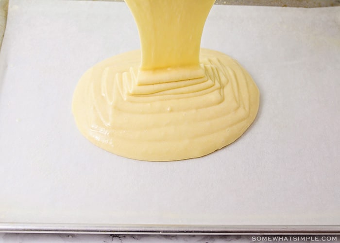 cake batter being poured onto a baking sheet