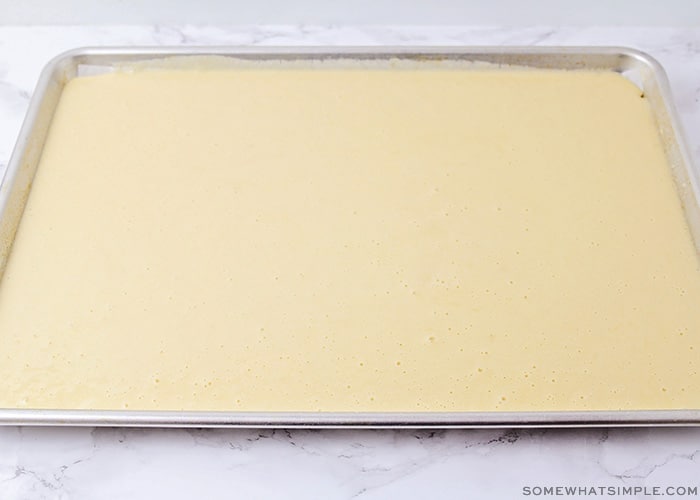 cake batter spread evenly over a baking sheet