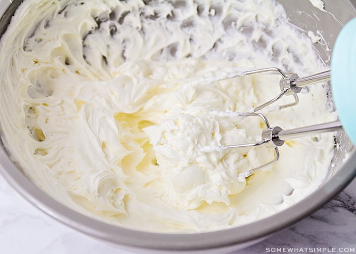 a cream cheese cake filling being mixed in a bowl