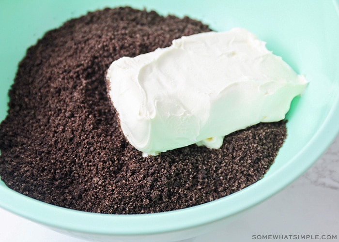 crushed oreos and a brick of cream cheese in a bowl