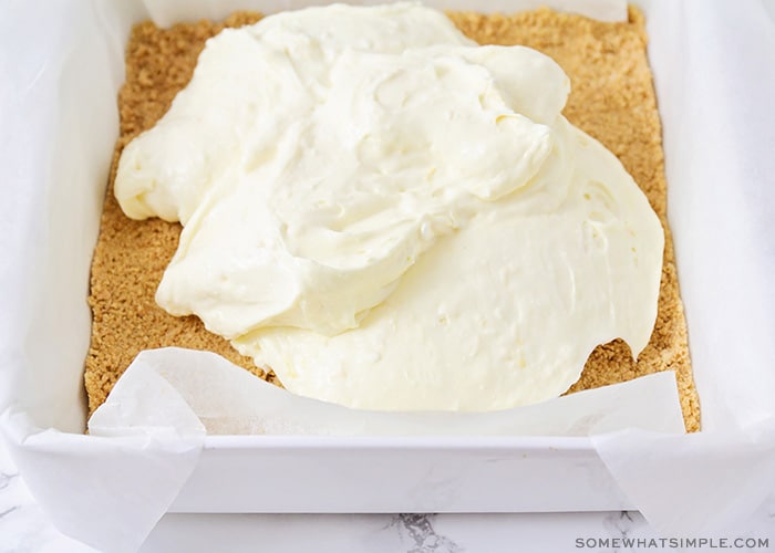 a cream cheese mixture poured on top of a graham cracker crust