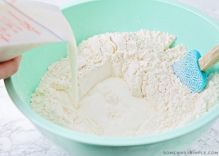 buttermilk being poured into a bowl of flour