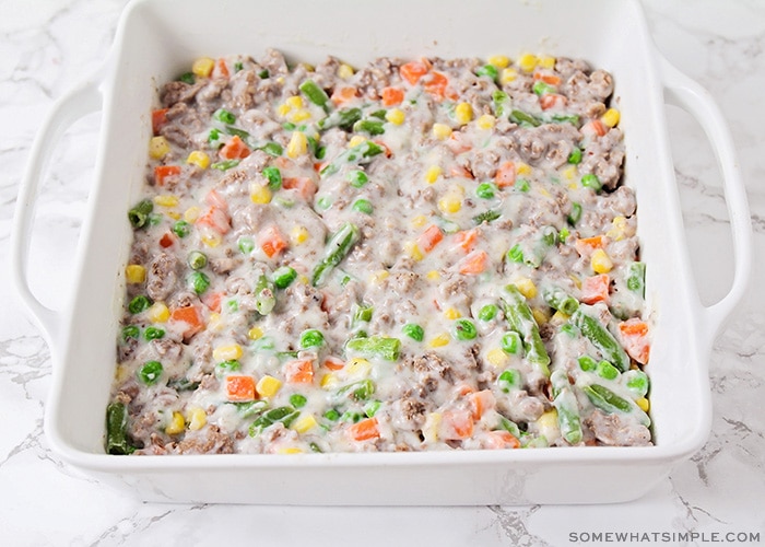 a mixture of sauce, ground beef and vegetables in a baking dish