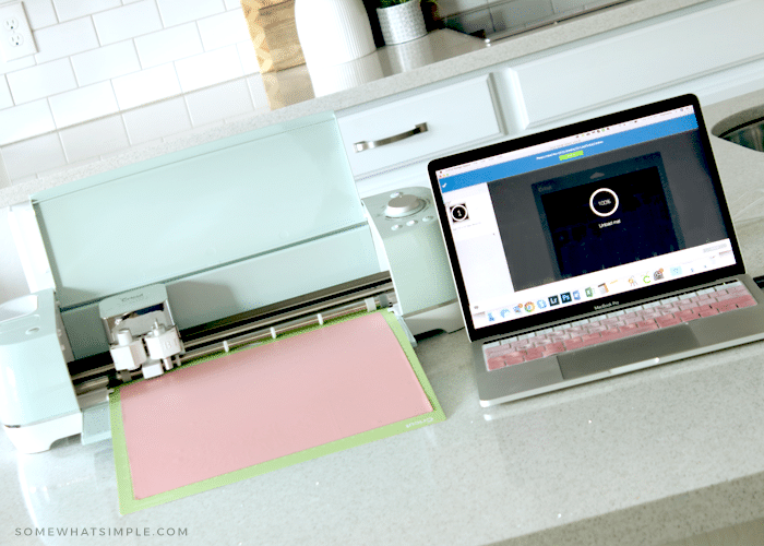 a cricut machine next to a laptop