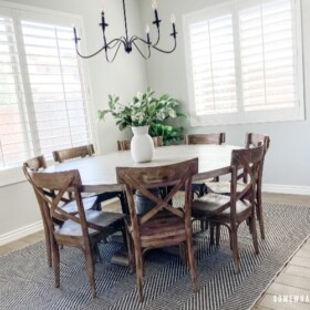 Dining room with round table on rug with simple centerpiece