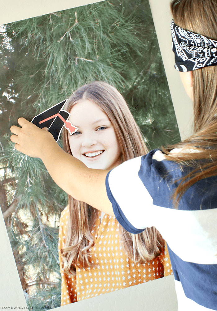 Teenager playing Pin the Cap on the graduate game.