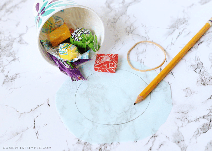 paper cup filled with candy and a pencil tracing around the edge of the cup on a piece of paper