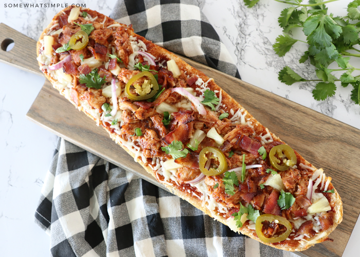 a loaf on a cutting board of BBQ Chicken French Bread Pizza