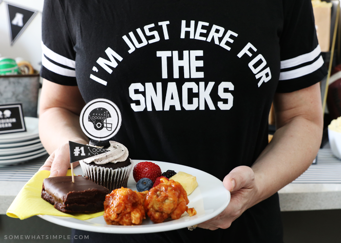 woman wearing black shirt holding a plate of party foods