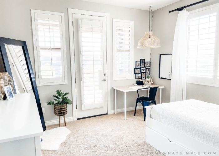 girls modern boho bedroom with standing mirror, desk, dresser and bed