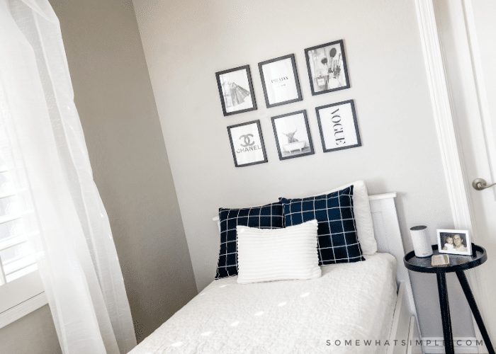 Twin bed with white quilt and black throw pillows