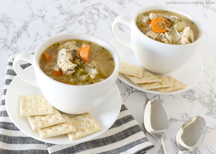 cups of chicken and rice soup with crackers on a counter