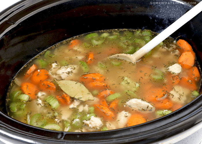 stirring the ingredients of a chicken and rice soup in the crockpot