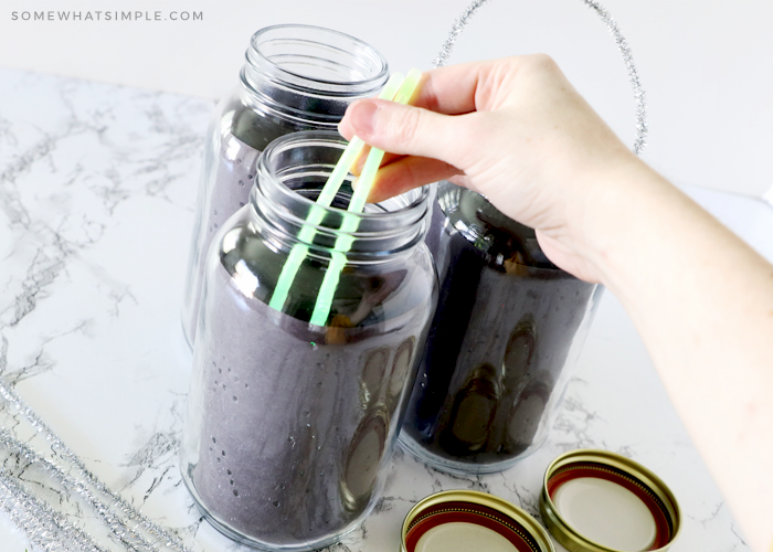 placing glow sticks inside a mason jar to make a lantern