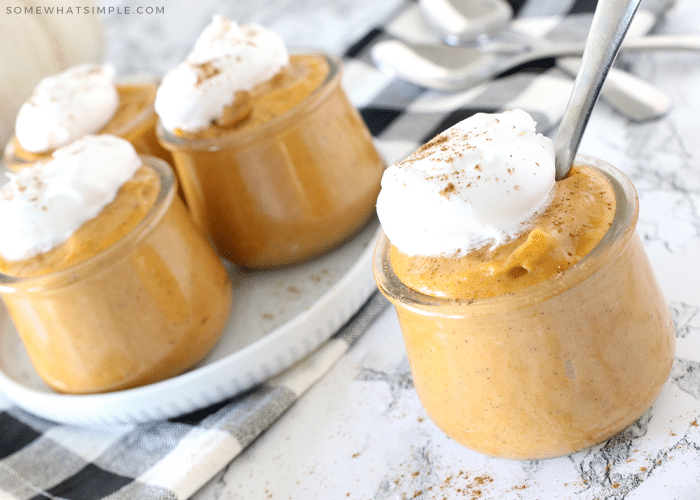 small cups of pumpkin pudding with whipped cream