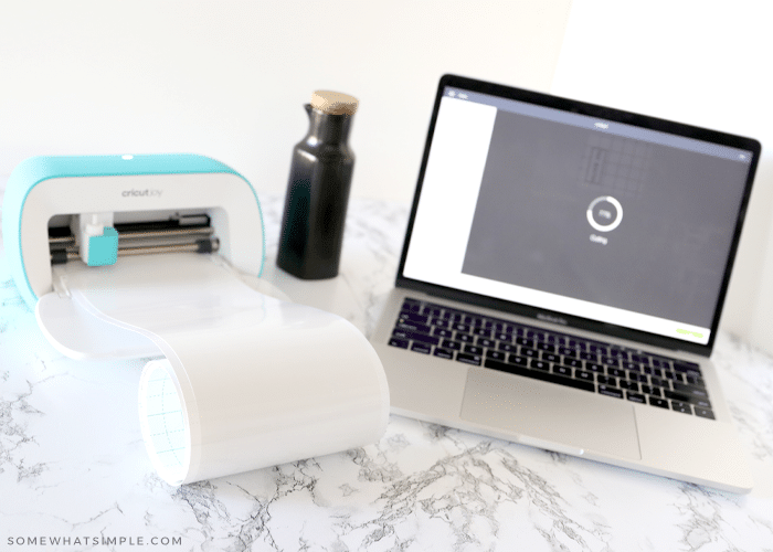 laptop and cricut supplies on a counter