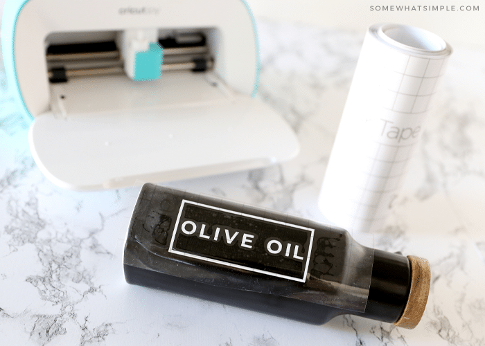 olive oil bottle on the counter with a cricut machine in the back