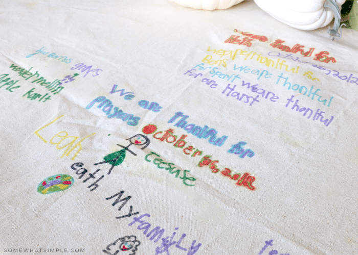 6 year old marker drawings of things she is thankful for on a thanksgiving tablecloth