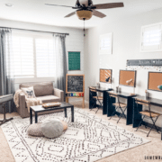 neutral homeschool room with desks, a couch and rug