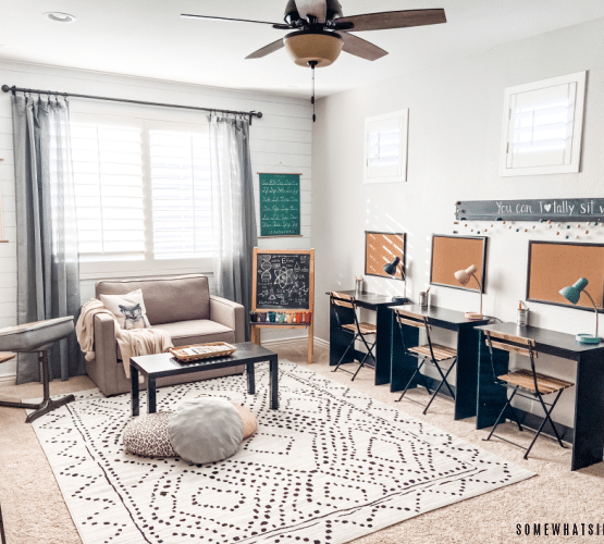 neutral homeschool room with desks, a couch and rug