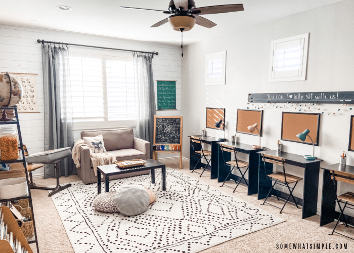 neutral homeschool room with desks, a couch and rug