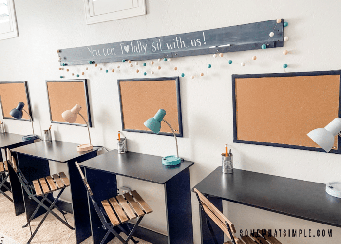 row of black desks with colorful desk lamps