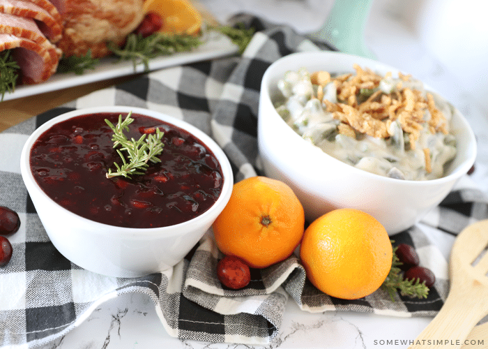 cranberry sauce, fresh oranges, and green bean casserole sitting on a counter