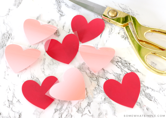 red and pink hearts next to gold scissors on a white counter