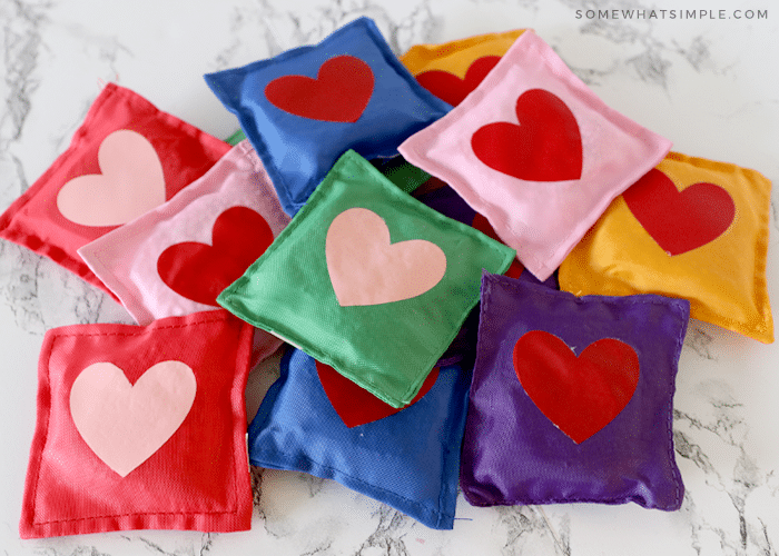 pile of rainbow bean bags with hearts on the center of them