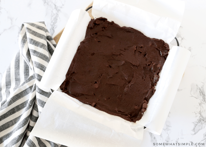 raw brownie batter in a square pan