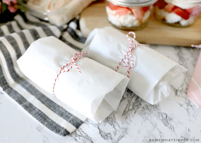 sandwiches wrapped in white parcment paper and bakers twine