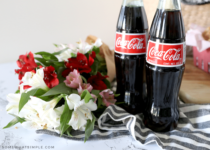 bouquet of flowers next to two bottles of coke