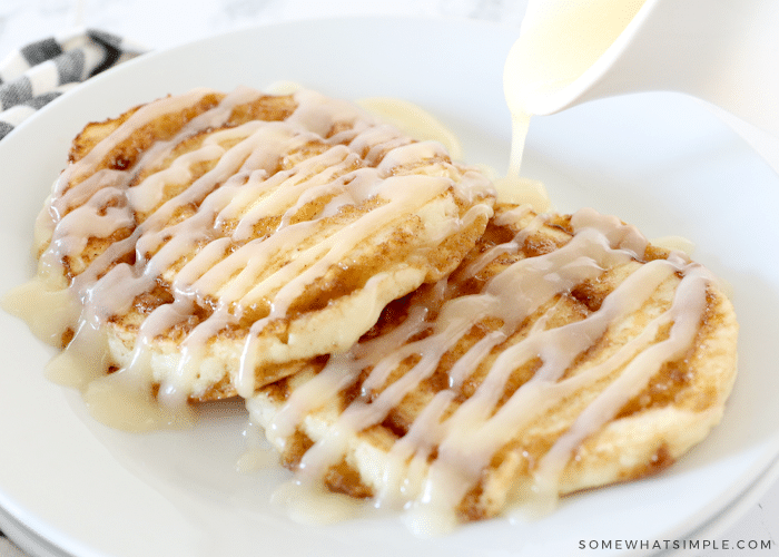 drizzling glaze over cinnamon roll pancakes