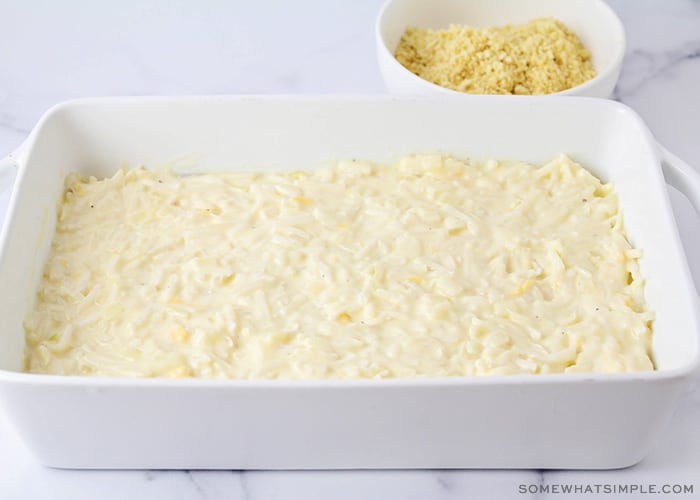 crushed crackers behind a casserole pan of cheesy potatoes