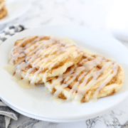 Cinnamon Roll Pancakes on a white plate with striped napkin